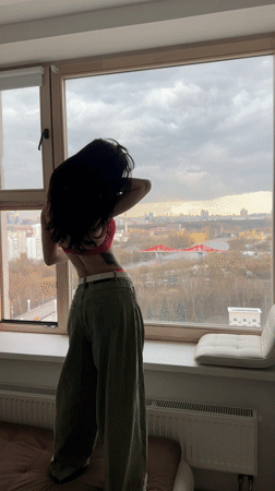 Woman in colorful attire observed at window in Khimki