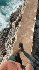 Tourist walks scenic cliff paths in Petrovac, Montenegro