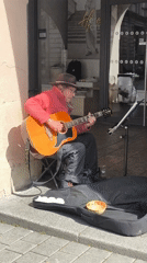 Street musician performs acoustic guitar in downtown Strasbourg