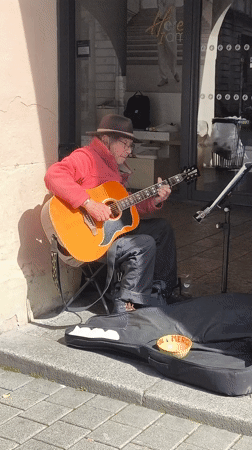 Street musician performs acoustic guitar in downtown Strasbourg
