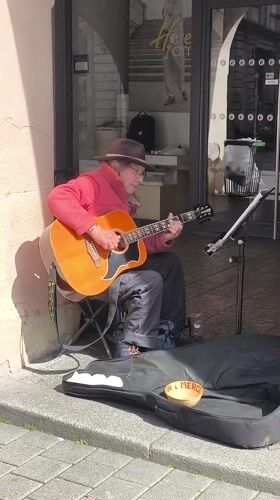 Street musician performs acoustic guitar in downtown Strasbourg