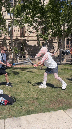 Young adults stage playful mock battle in Barcelona park