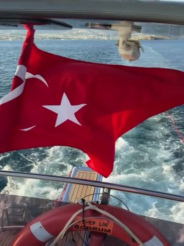 Sailing near Bodrum with a Turkish flag and towed dinghy