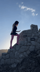 Woman climbs stone structure in Montenegro mountain village
