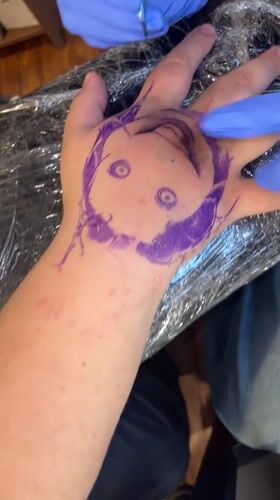 Tattoo artists work on clients at Buenos Aires studio