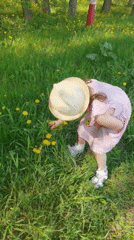 Girl picks dandelions in Perm park during spring morning
