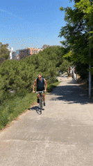 Cyclist rides paved path in Barcelona park area