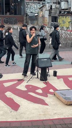 Street musician busks with ukulele on Seoul sidewalk