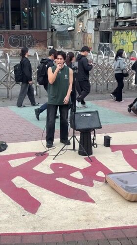 Street musician busks with ukulele on Seoul sidewalk
