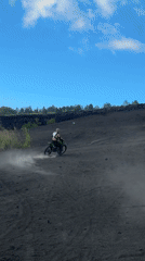 Motocross rider navigates volcanic terrain near Kintamani, Indonesia