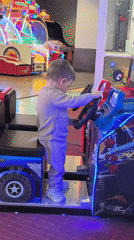 Toddler plays arcade games at entertainment center in Bulgaria