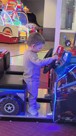 Toddler plays arcade games at entertainment center in Bulgaria