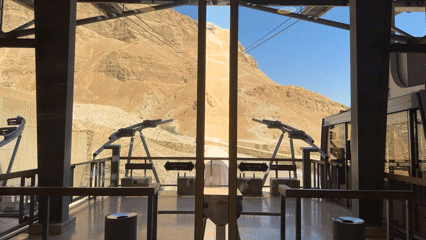 Inside Masada's cable car station, desert views through glass