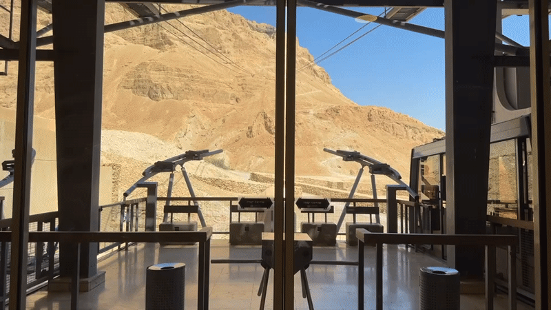 Inside Masada's cable car station, desert views through glass