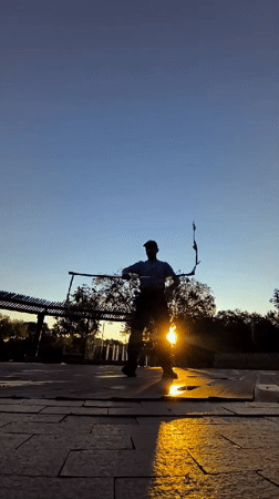 Nunchaku training session in a Qarağandı public plaza at sunset
