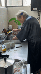 Elderly woman washing mushrooms in Buenos Aires kitchen