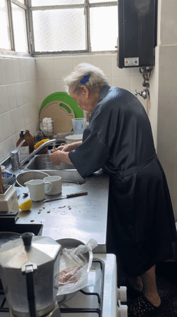 Elderly woman washing mushrooms in Buenos Aires kitchen