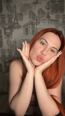 Posing and gesturing in front of Paris-themed wallpaper