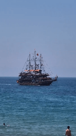 Pirate ship sails past Alanya beaches on clear morning