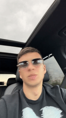 Young man films selfies in car driver's seat