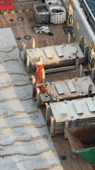 Supply vessel crew at work near an offshore drilling platform