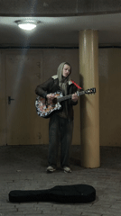 Street musician performs acoustic guitar in Hrodna underpass