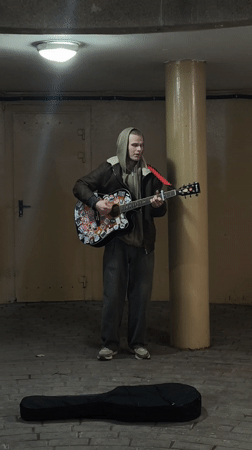 Street musician performs acoustic guitar in Hrodna underpass