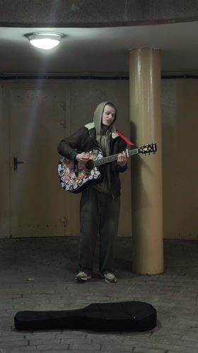 Street musician performs acoustic guitar in Hrodna underpass