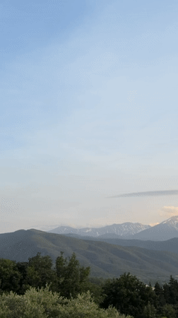 Green hills and snow-capped peaks captured near Rodès, France