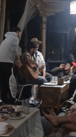 Late-night acoustic guitar session on a covered patio