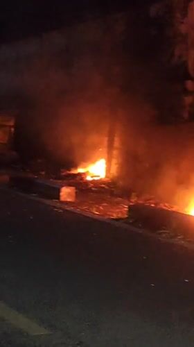 Roadside fires burn at night along a Da Lat street
