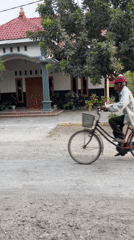 Bicycle and loaded truck share a dirt road in Kauman