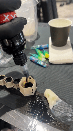 Person fills hexagonal containers with black ink in Moscow