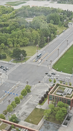 Early morning traffic flows through green city intersection