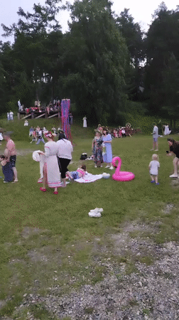 Midsummer festival at a lakeside clearing: dancing, flower crowns, pole