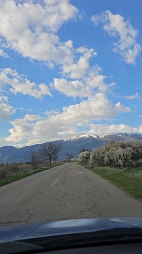 Worn road toward snowy mountains captured in Vedrare, Bulgaria