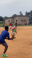 Young men play informal soccer match on dirt field