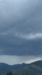 Storm light over coastal mountains and a bay town