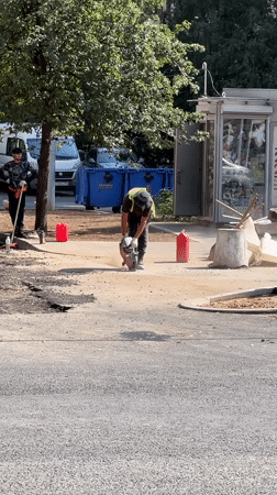 Road crew cuts into asphalt on a sunny street