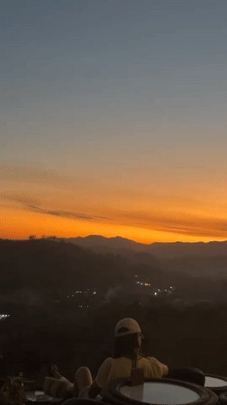 Sunset gathering at a hillside café overlooking Kuta's mountain valley