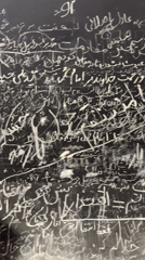 Chalk-written protest slogans cover a dark surface in Tehran