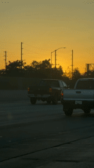 Los Angeles highway traffic flows under colorful sunset sky