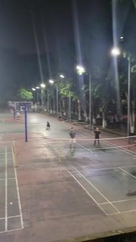 Badminton players active on wet outdoor courts in Shapingba
