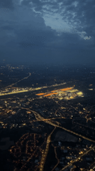 Brussels suburbs glow at night, airport runway visible from above