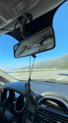 Driver travels coastal highway in Montenegro on sunny morning