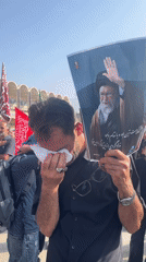 Public mourning in Tehran with a religious figure's portrait