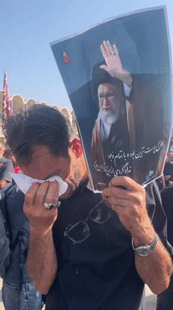 Public mourning in Tehran with a religious figure's portrait