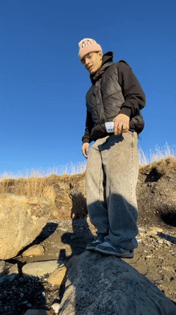 Beachcomber collects marine specimens along Ushuaia shore