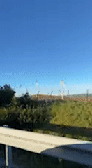 Rural Spanish countryside with wind turbines filmed from moving vehicle