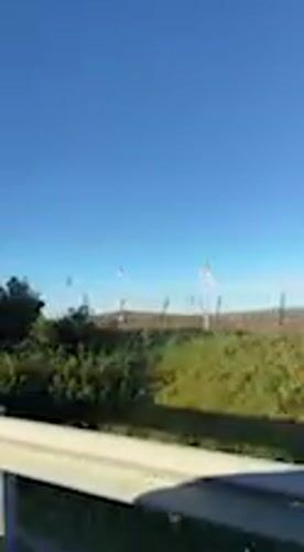 Rural Spanish countryside with wind turbines filmed from moving vehicle
